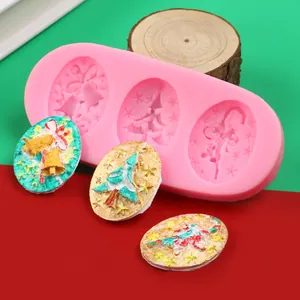 Close-up of pink Christmas egg-shaped silicone mold with finished tree and bell pieces