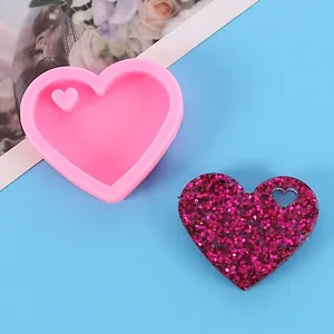 Heart-shaped pink silicone mold with finished glittery resin heart for DIY keychains
