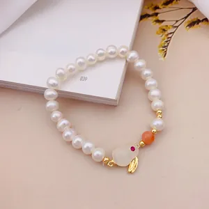 Dettaglio ravvicinato di un elegante bracciale in perle con ciondolo a coniglio in opale