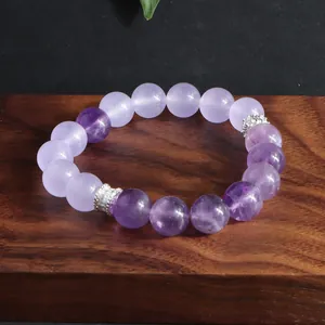 Detalle de pulsera de amatista natural y cuentas de lavanda sobre base de madera