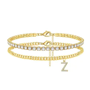 Layered gold anklet set featuring a crystal tennis chain and a Cuban link with a Z pendant
