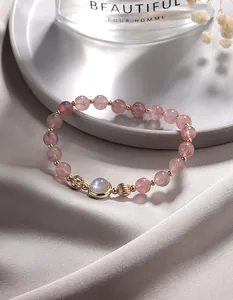 Nahaufnahme eines Erdberequarz-Armbands mit einem zentralen Mondstein in der Mitte.