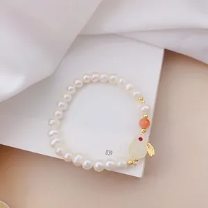 Primo piano del ciondolo a coniglio in occhio di gatto su un bracciale di perle