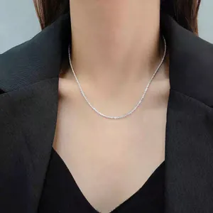 Detailed view of a sparkling silver star Chopin chain necklace worn on a model's neck