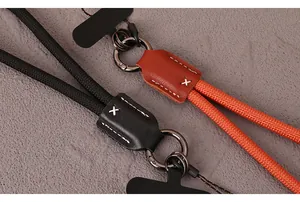 Detail showing the nylon braided phone wrist strap with leather stitch and metal ring.
