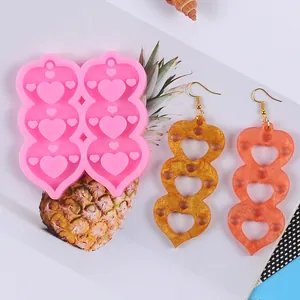 Detailed view of pink heart silicone earring mold with finished resin craft samples