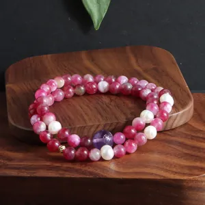 Detail van een dubbele armband met roze toermalijn, paarse amethist en witte natuurlijke parels