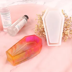Detailed view of a coffin-shaped silicone resin mold with a colorful finished resin sample.