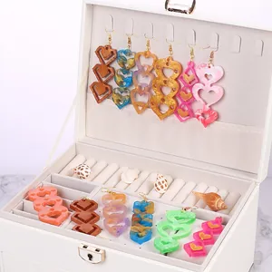 Handmade colorful resin heart drop earrings displayed neatly in a white jewelry box
