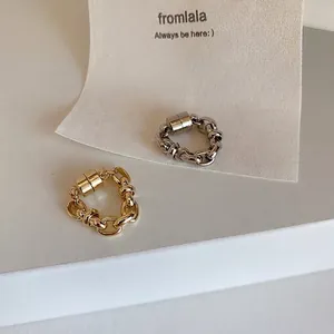 Detailed macro view of gold and silver metallic magnetic chain ear cuffs for non-pierced ears