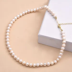 Vue détaillée d'un collier de perles d'eau douce baroques avec fermoir mousqueton doré.