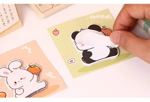 Detail van een hand die een schattig panda-vormig cartoon plaknotitieblokje afpelt