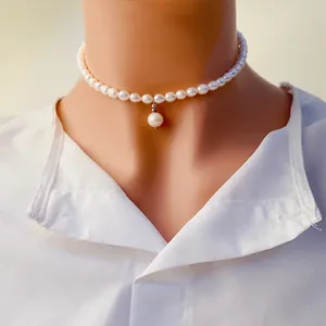 Gros plan d'un élégant collier ras du cou en perles d'eau douce blanches avec pendentif