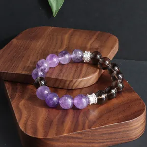 Detalle de primer plano de pulsera de amatista natural y cuarzo ahumado en madera.
