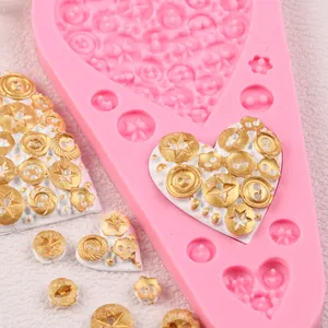 Primo piano dello stampo in silicone rosa per decorazioni a bottone e cuori dorati