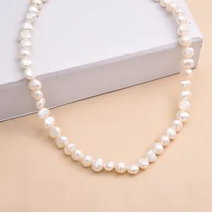 Gros plan d'un collier de perles d'eau douce baroques naturelles aux reflets doux