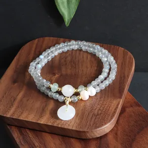 Nahaufnahme eines zweireihigen Perlenarmbands aus Labradorit mit weißem Jade-Anhänger