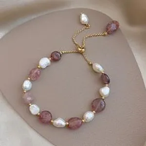 Dettaglio del bracciale a catena dorata regolabile con perle barocche e agata viola.