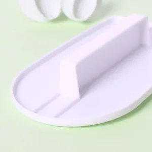Detail view of the handle of a white plastic fondant cake smoother and embossing tool