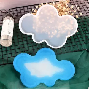 Cloud-shaped silicone mold for DIY resin coasters showing finished blue and white piece
