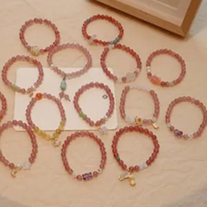 Dettaglio di braccialetti in perline di agata naturale con ciondoli a farfalla e luna