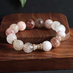Makroaufnahme eines Naturstein-Armbands aus Super Seven Kristallen mit Goldakzenten.