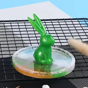 Dettaglio di un coniglio in resina verde fai-da-te su un vassoio glitterato colorato