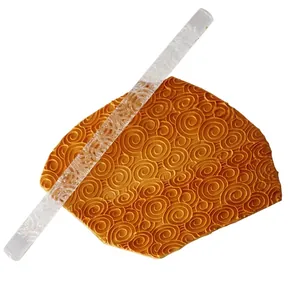 Close-up of clear acrylic rolling pin showing embossed swirl pattern on textured fondant