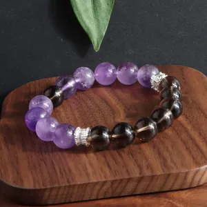 Detalle de primer plano de pulsera de amatista natural y cuarzo ahumado sobre madera