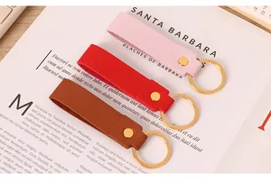 Vue détaillée de porte-clés minimalistes en cuir PU rose, rouge et marron très élégant.