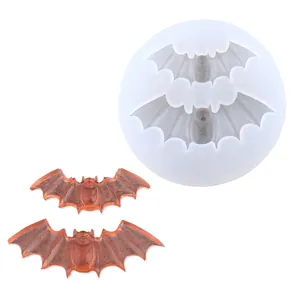 Detail of bat-shaped silicone mold with orange resin bat charms for Halloween DIY