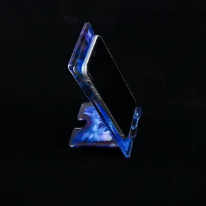 Close-up view of artistic blue and purple swirl resin mobile phone stand for desk