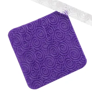 Detailed macro view of swirl engraved pattern on purple fondant mat and acrylic rolling pin