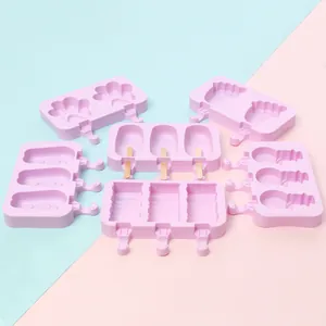 Collection of various pink silicone ice pop molds in cute shapes including wooden sticks