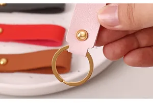 Détail d'un porte-clés en similicuir rose doté d'un anneau en métal doré brillant