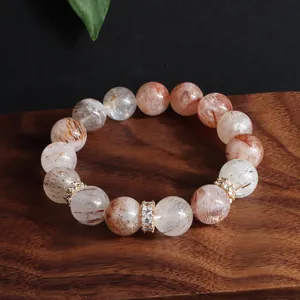 Detailansicht eines Armbands aus natürlichen Super Seven Kristallen mit goldenen Abstandsperlen