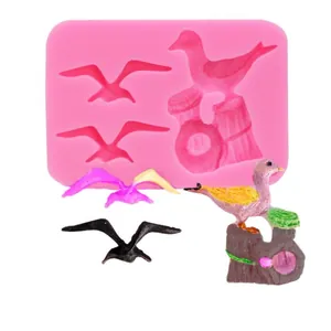 Detailed view of pink silicone seagull mold with finished bird cake decorations