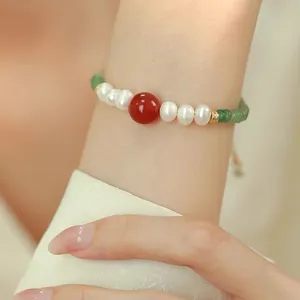 Close-up of elegant beaded bracelet with freshwater pearls, green aventurine, and red agate