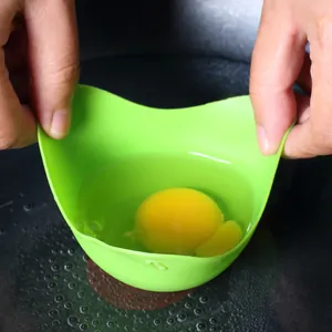 Vista ravvicinata di un uovo crudo in uno stampo per uova in camicia di silicone.
