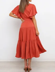 Back view of a bohemian tiered midi dress with ruffle sleeves and rust orange color