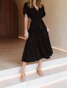 Detailed view of a black V-neck ruffled short sleeve bohemian summer dress on a model