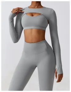 Close-up detail of grey yoga set featuring long sleeve cutout shrug over a sports bra