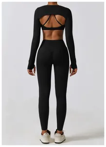 Back view of black long-sleeve yoga shrug with cutout detail and leggings set