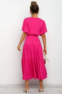 Back view of a vibrant fuchsia Bohemian long dress with ruffled sleeves and tiered skirt.