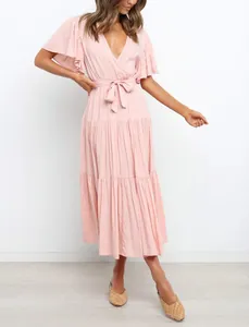 Close-up of elegant pink V-neck Bohemian dress featuring ruffle sleeves and waist tie detail