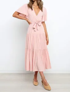 Detail view of a pink V-neck bohemian maxi dress with ruffle sleeves and belted waist.