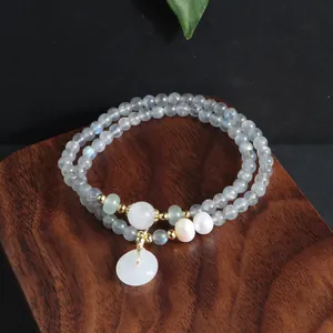 Nahaufnahme eines zweireihigen Labradorit-Armbands mit einem weißen Jaspis-Anhänger.