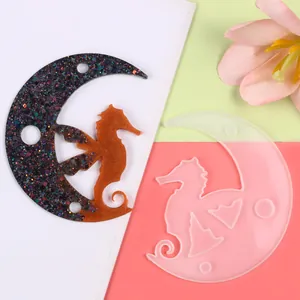 Macro view of translucent silicone mold for moon pendant with seahorse and resin sample