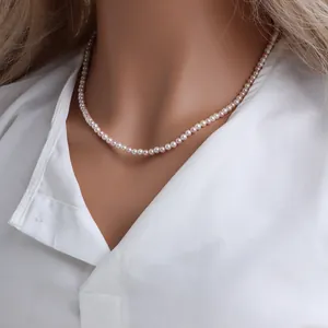 Élégant collier ras du cou en perles colorées porté sur chemise blanche