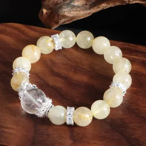 Primer plano detallado de una pulsera de cuarzo rutilado dorado con cuentas de plata